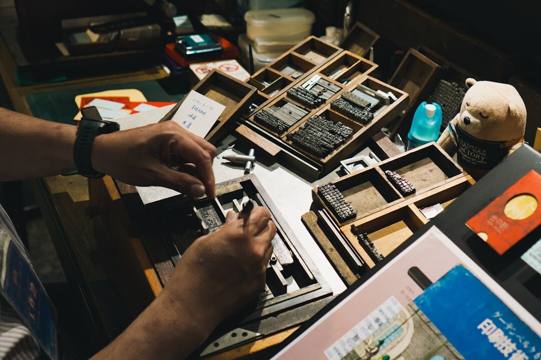 Hands holding old family photographs on a wooden table